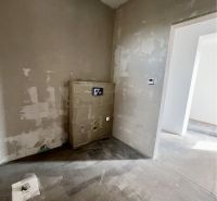 The interior of a family house with plastered walls and a floor awaiting finishing.