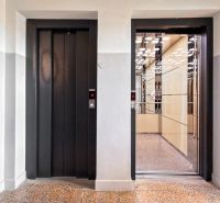 Open elevator doors with reflection of lights, 3-room apartment.