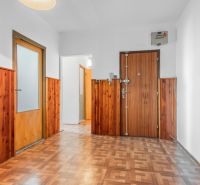 A hallway of a 3-room apartment with wooden paneling and a floor with a wooden decor.
