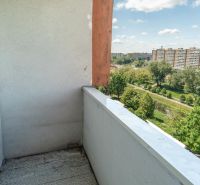 View of greenery and panel buildings from a balcony in Bratislava on Lachova Street.