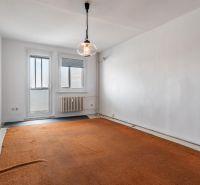 A room with an orange carpet, white wall, window, and radiator in a 3-room apartment.