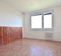 An unfurnished room with a window, a radiator, and a wall with wood paneling in a 3-room apartment.