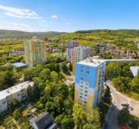Aerial view of apartment buildings on Sadmelijská Street in Bratislava - Rača, surrounded by greenery.