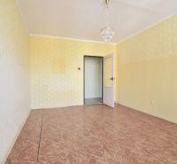 A room with wallpaper and a chandelier in a 3-room apartment, with a wooden decor floor.