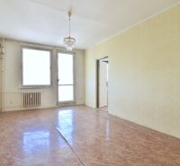Bright living room in a 3-room apartment with a chandelier and wood-patterned flooring.