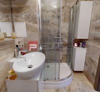 A bathroom in a 2-room apartment with a bathtub and a sink, tiled with ceramic tiles.