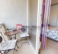 A balcony with metal furniture and a view, connected to a room in a 2-room apartment.