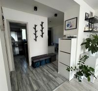 Interior of a 3-room apartment with a wooden decor floor and minimalist decorations.