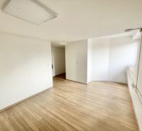 The interior of an office with white walls and a floor with a wood decor.