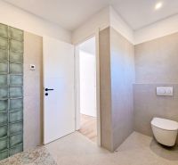 A bathroom in a 3-room apartment with ceramic tiles and a wooden decor floor.