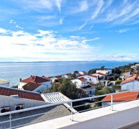 A view from a 3-room apartment in Petrcane of the sea and rooftops of houses.