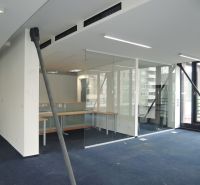 Offices with glass partitions and blue carpet.