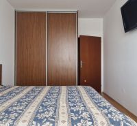 A bedroom with a large built-in wardrobe in a 2-room apartment.