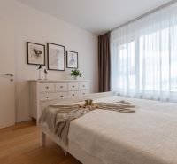 Bedroom with white furniture in a two-room apartment, floor with wood decor.