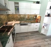 A kitchen in a 3-room apartment with a wooden decor floor and a green granite countertop.