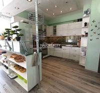 A kitchen in a 3-room apartment with a wooden decor floor and modern cabinet arrangement.