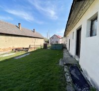 The garden at the family house on Tehelná in Drienov with a grassy plot and visible structures.