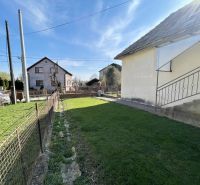 The garden of the family house on Tehelna Street in Drienov with a manicured lawn and fencing.