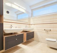 A bathroom in a family house with a double sink and tiles in a wood decor.
