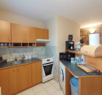 A kitchen in a 2-room apartment with a wooden decor and light tiles.