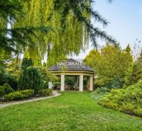 The garden of a family house in Žabokreky nad Nitrou with a gazebo surrounded by lush greenery.