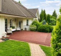A family house in Žabokreky nad Nitrou with a terrace and a landscaped garden surrounded by greenery.