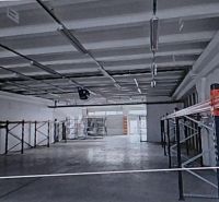 Spacious warehouses and halls with metal shelves and concrete floors.