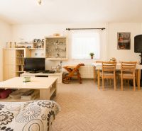 Living room in a family house with a dining table, cabinet, and television.