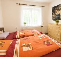 Bright bedroom with a bed and a dresser in a family house.
