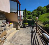 The terrace of a family house in Banky with a view of greenery and a blue sky.