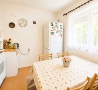 Kitchen in a family house with a dining table, stove, and refrigerator.