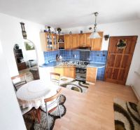 A kitchen in a family house with blue tiles and a floor with a wood decor.