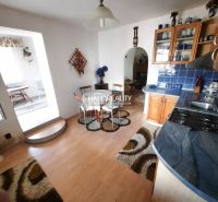 A kitchen in a family house with blue tiles and a wooden decor floor.