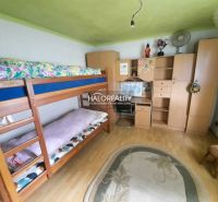 A room in a family house with a bunk bed, furniture, and a wooden decor floor.