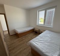 A bedroom with two beds and a wooden decor floor in a 3-room apartment.