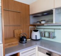A kitchen in a 3-room apartment with a wooden decor on the wall and appliances.