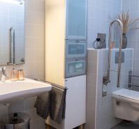 Bathroom in a 3-room apartment with a sink, toilet, and white tiles.