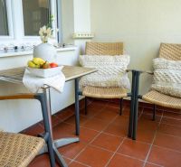 Three chairs and a table with a bowl of fruit on the terrace, 3-room apartment.