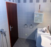 Bathroom in a 3-room apartment with tiles, a washing machine, and a cabinet.