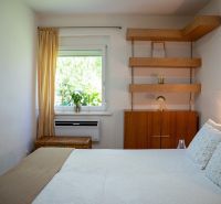Bedroom in a 3-room apartment with shelves and a window with a curtain.