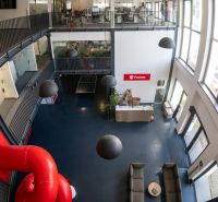 Offices with glass spaces, a staircase, and a red slide, Packeta.