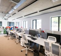 Offices with white desks and white chairs with gray backrests.