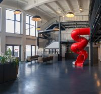 Offices with a red slide, open space, and staircase.