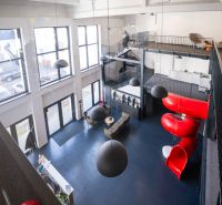 Office interiors with a slide, modern design, and large windows.