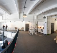 Offices with wood-patterned flooring, modern furniture, and high ceilings.