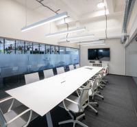 Conference room in offices with a long table and chairs, modern lighting.