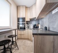 Compact kitchen with wood-patterned flooring, bright interior, equipment, and seating.