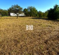 A plot for residential use in Moravské Lieskové with well-maintained green grass and trees.