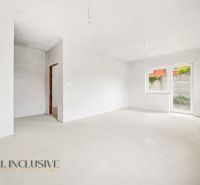 An empty room in a 3-bedroom apartment with a window and access to the terrace.