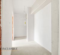 Interior of a 3-room apartment with white walls in a rough construction.